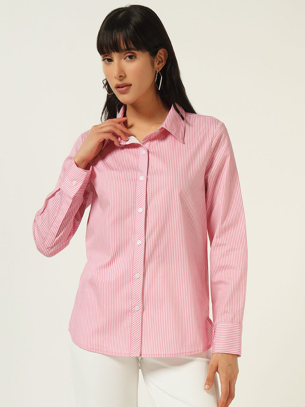 Woman wearing a pink and white striped shirt against a plain background